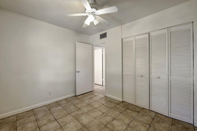 unfurnished bedroom with ceiling fan, light tile patterned floors, and a closet