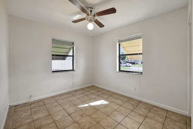 tiled spare room with ceiling fan