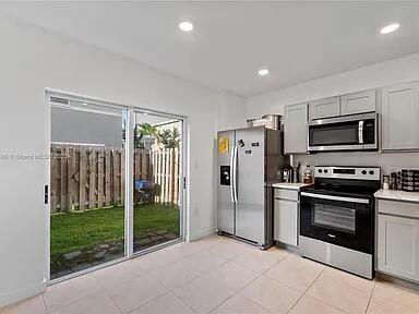 kitchen with appliances with stainless steel finishes, gray cabinets, and light tile patterned flooring