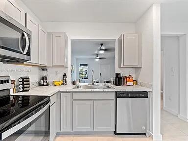 kitchen featuring light tile patterned flooring, appliances with stainless steel finishes, and sink