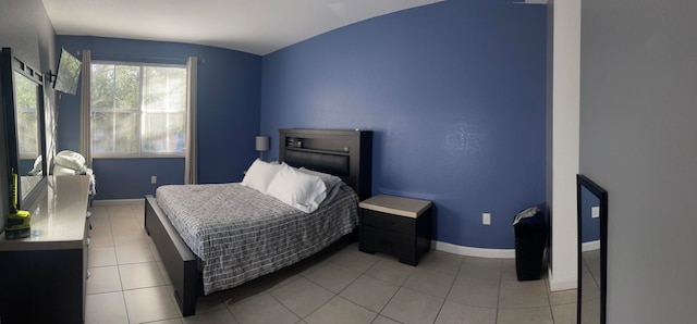 bedroom with light tile patterned floors and vaulted ceiling