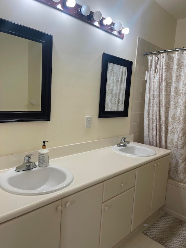 bathroom with tile patterned floors, shower / bath combo with shower curtain, and vanity