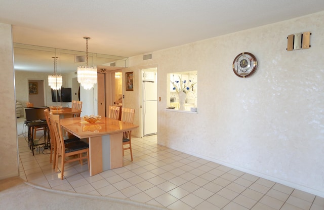 tiled dining area featuring a notable chandelier