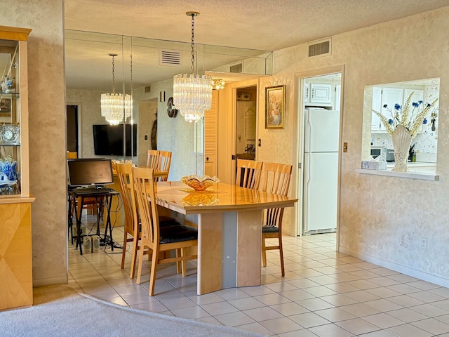 tiled dining area featuring a chandelier and a textured ceiling