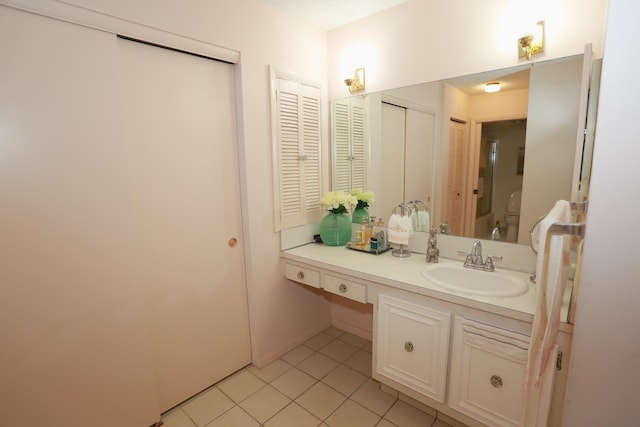 bathroom featuring tile patterned floors, vanity, and toilet