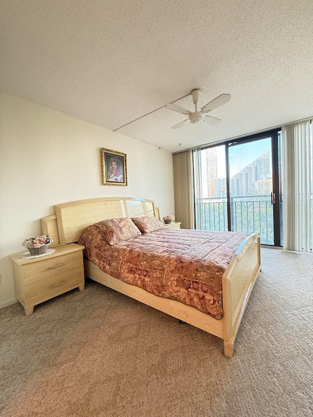 carpeted bedroom featuring access to exterior, ceiling fan, floor to ceiling windows, and a textured ceiling