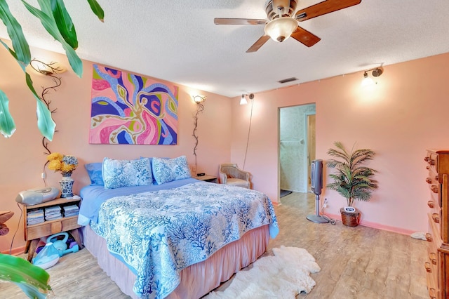 bedroom with ceiling fan, a textured ceiling, and light wood-type flooring