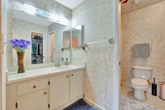 bathroom featuring tile patterned flooring, vanity, and toilet