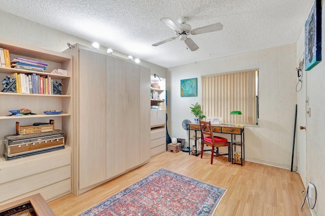 office space featuring ceiling fan, light hardwood / wood-style floors, and a textured ceiling