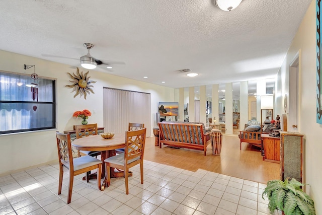 dining area with ceiling fan, light hardwood / wood-style floors, and a textured ceiling