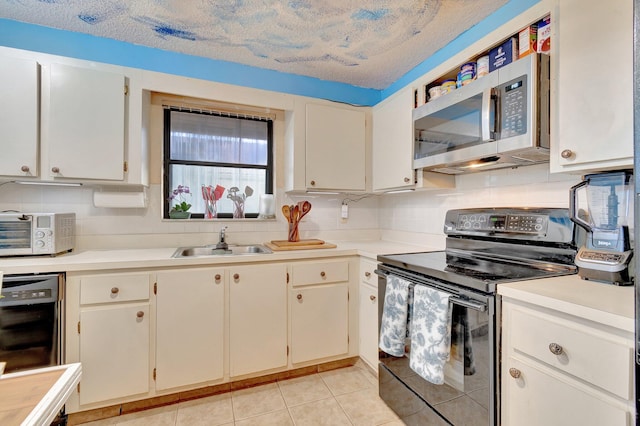 kitchen featuring white cabinetry, sink, black appliances, and a textured ceiling