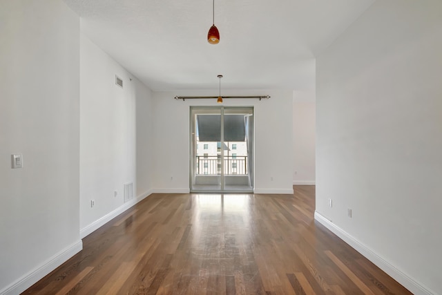 unfurnished room with dark wood-type flooring