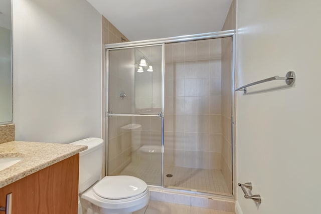 bathroom featuring tile patterned floors, a shower with door, vanity, and toilet