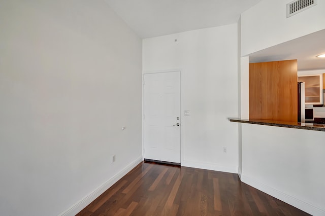 unfurnished room with dark hardwood / wood-style flooring