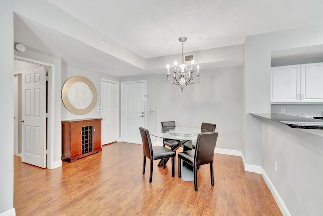 dining room featuring light hardwood / wood-style floors and a chandelier