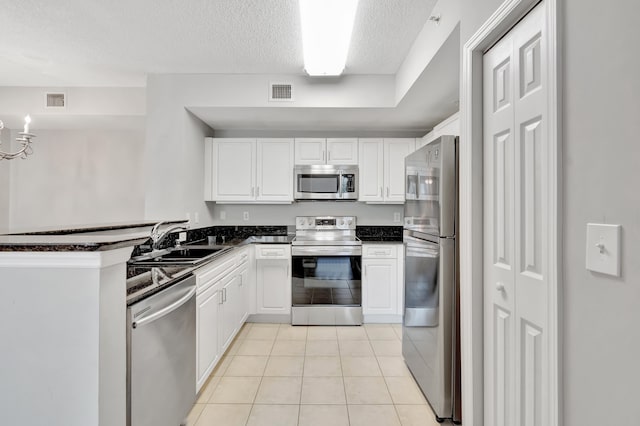 kitchen featuring white cabinetry, sink, stainless steel appliances, a textured ceiling, and light tile patterned floors