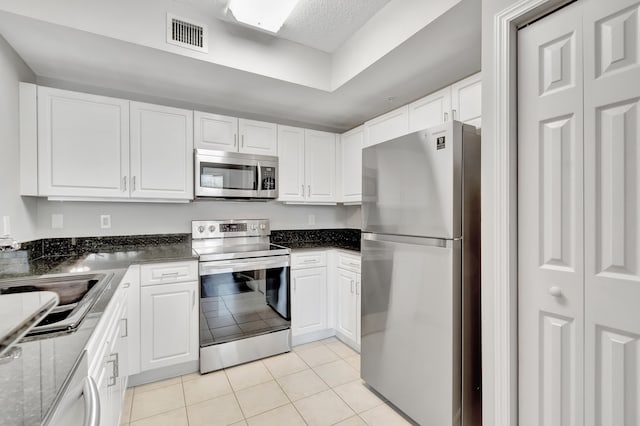 kitchen featuring light tile patterned floors, white cabinetry, and appliances with stainless steel finishes