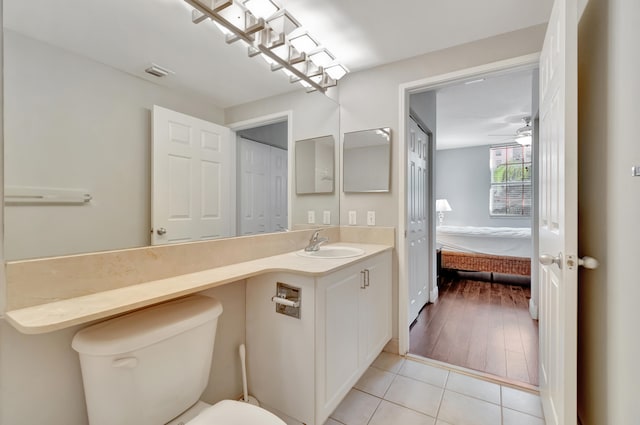 bathroom with wood-type flooring, vanity, toilet, and ceiling fan