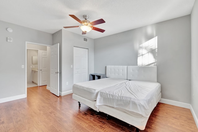 bedroom with ceiling fan, a closet, a textured ceiling, and hardwood / wood-style flooring