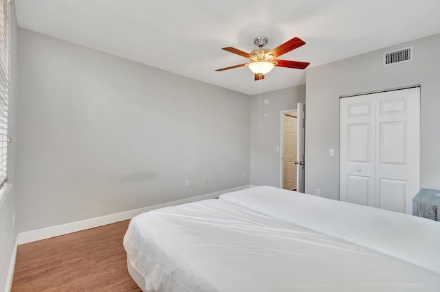 bedroom featuring hardwood / wood-style floors, ceiling fan, and a closet