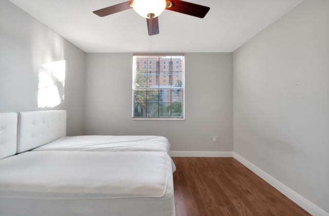 bedroom with ceiling fan and dark hardwood / wood-style flooring