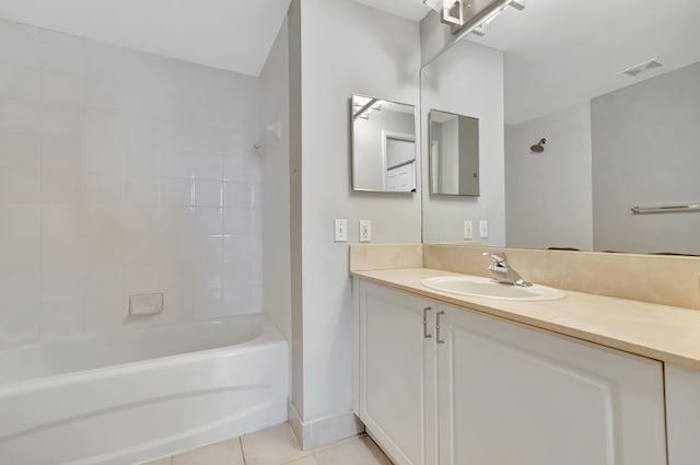 bathroom featuring tile patterned flooring, vanity, and tiled shower / bath