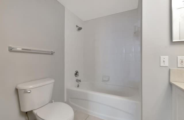 full bathroom featuring tile patterned floors, vanity, toilet, and tiled shower / bath