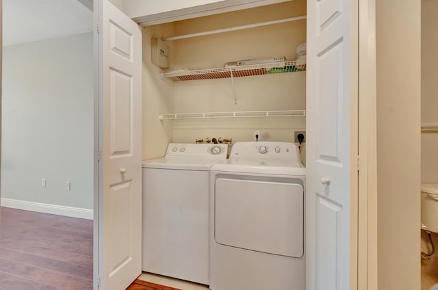 clothes washing area featuring washer and dryer and hardwood / wood-style flooring