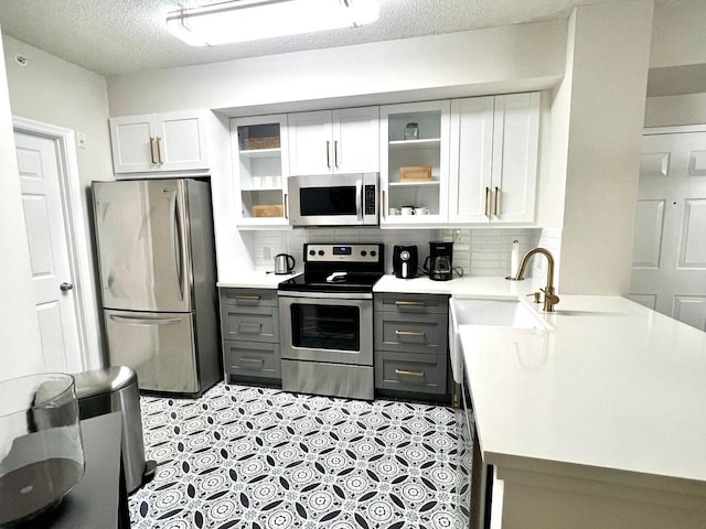 kitchen featuring appliances with stainless steel finishes, tasteful backsplash, white cabinetry, and gray cabinetry