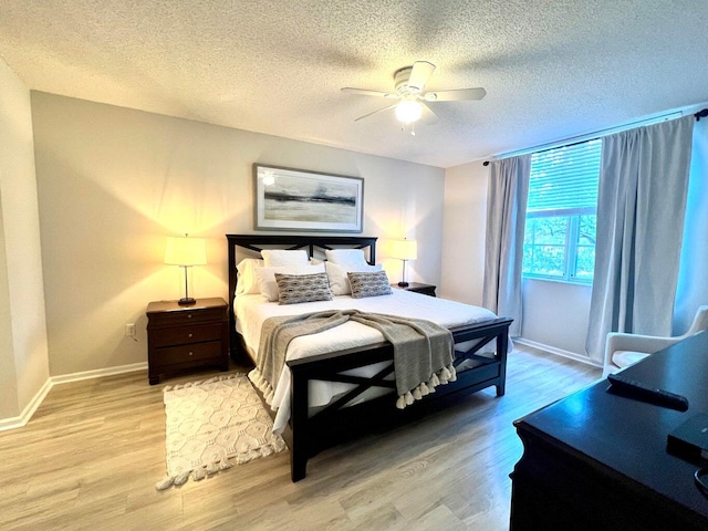 bedroom featuring ceiling fan, a textured ceiling, and light hardwood / wood-style flooring