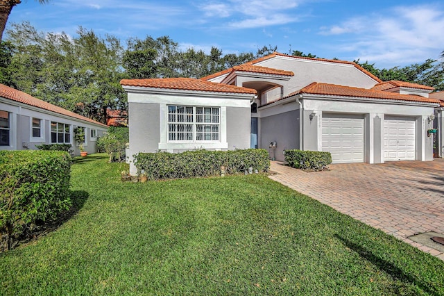 mediterranean / spanish-style home featuring a front yard and a garage