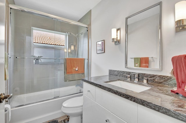 full bathroom featuring vanity, toilet, and combined bath / shower with glass door