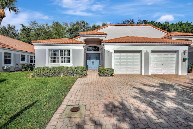 mediterranean / spanish-style house featuring a garage and a front yard