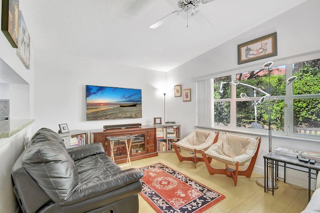 living room featuring light hardwood / wood-style floors, ceiling fan, and lofted ceiling