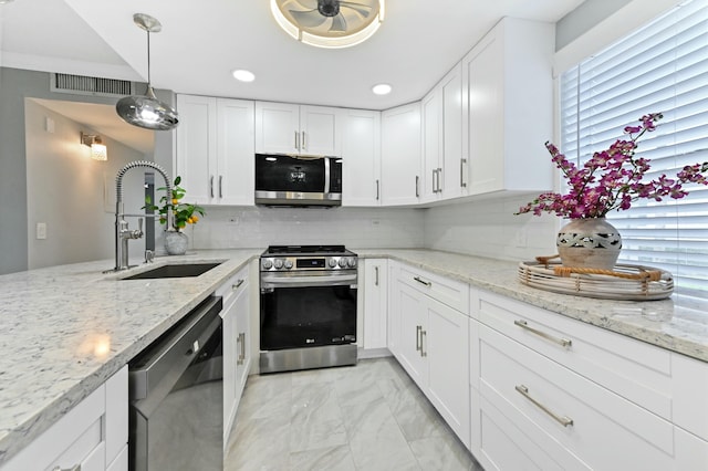 kitchen with white cabinets, sink, stainless steel appliances, and hanging light fixtures