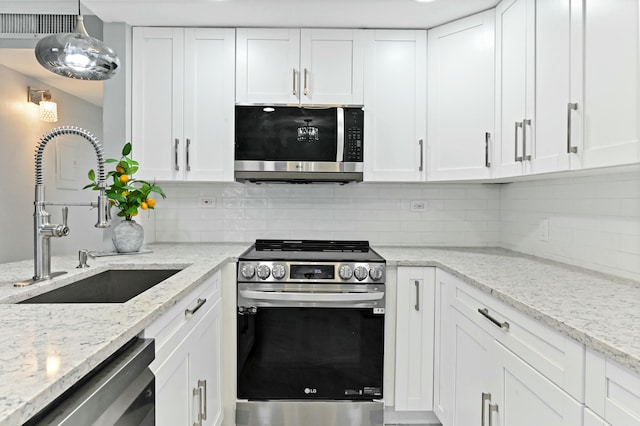 kitchen with pendant lighting, stainless steel appliances, white cabinetry, and sink