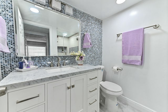 bathroom with tasteful backsplash, vanity, and toilet