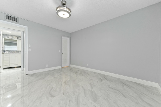 unfurnished room with a textured ceiling