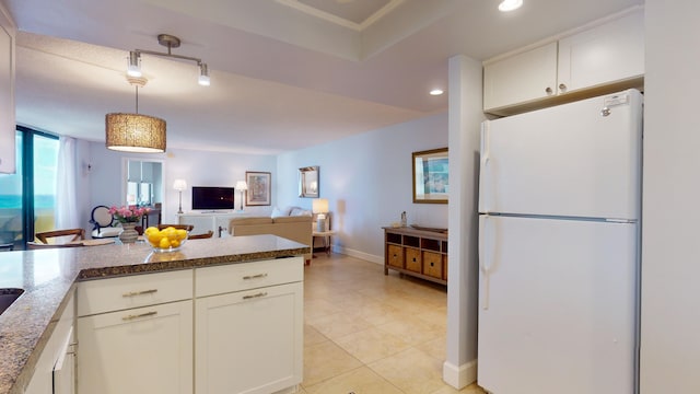 kitchen featuring kitchen peninsula, white refrigerator, decorative light fixtures, white cabinets, and light tile patterned flooring