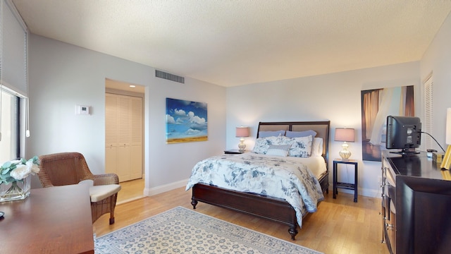 bedroom with light wood-type flooring and a closet