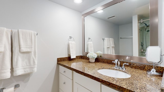 bathroom with vanity and a shower with shower door