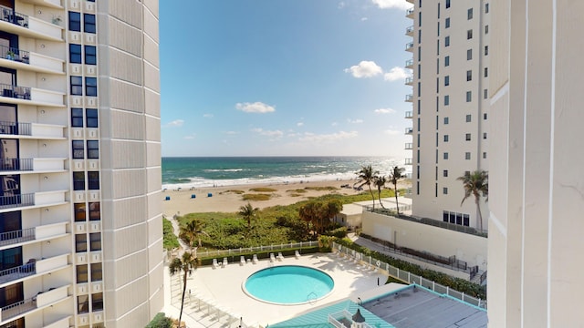 view of pool with a water view and a beach view