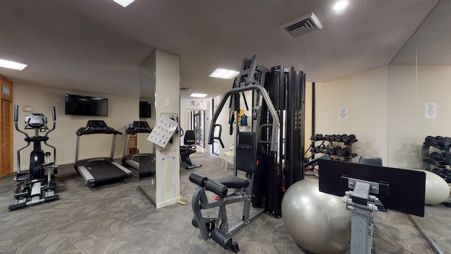 gym featuring carpet and a textured ceiling