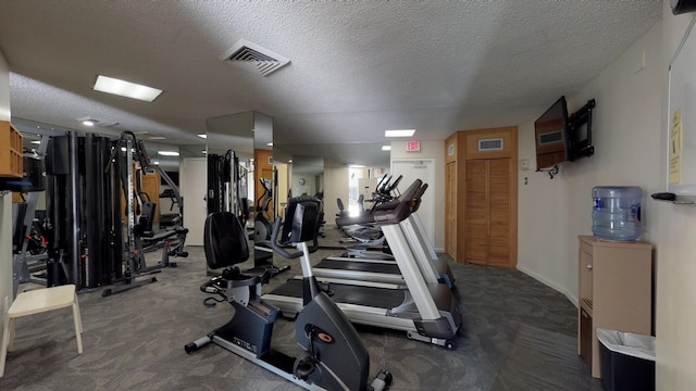 workout area featuring carpet and a textured ceiling