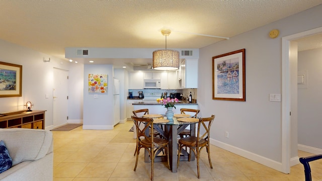 tiled dining room with a textured ceiling