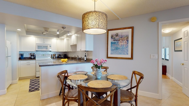 tiled dining space featuring ceiling fan and sink