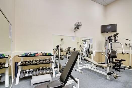 exercise room featuring a towering ceiling