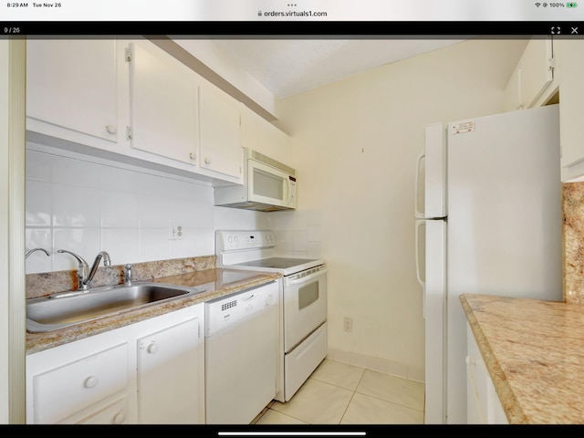 kitchen featuring decorative backsplash, sink, white cabinets, and white appliances