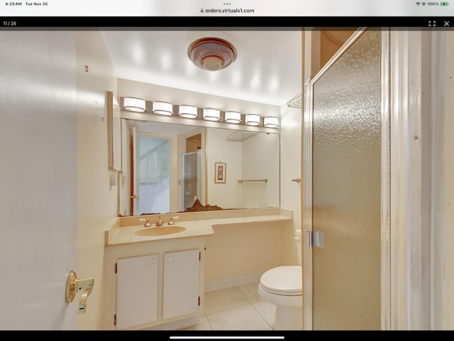 bathroom with tile patterned floors, vanity, toilet, and a shower with shower door