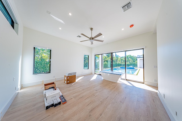 unfurnished living room featuring plenty of natural light, ceiling fan, and light wood-type flooring